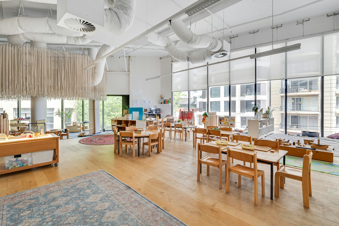 Modern classroom interior with organized tables and play stations.