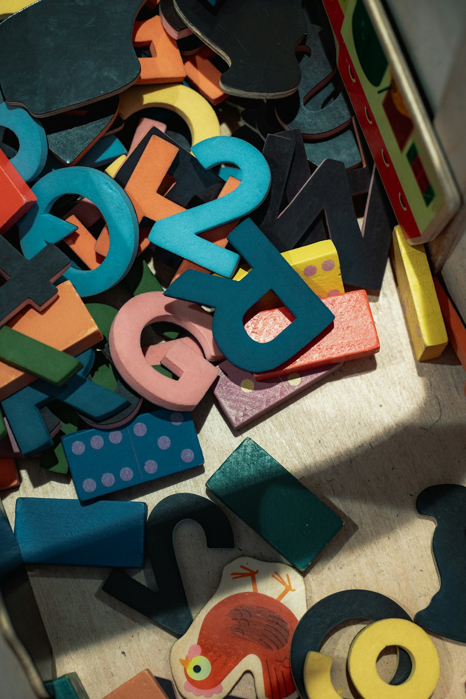 Colorful wooden educational toys stored inside a wooden box.